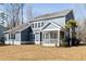 Rear exterior view of a two-story home with blue siding, white trim and a screened in porch at 5680 Barbary Coast Rd, Hollywood, SC 29449