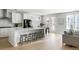 Modern kitchen boasts white cabinets, a spacious island with seating, and an open layout adjoining the dining and living areas at 5680 Barbary Coast Rd, Hollywood, SC 29449