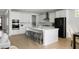 Modern kitchen with white cabinets, stainless steel appliances, and a large center island with bar stool seating at 5680 Barbary Coast Rd, Hollywood, SC 29449