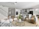 Bright living room with open floor plan leading into a modern white kitchen and featuring stylish neutral furniture at 5680 Barbary Coast Rd, Hollywood, SC 29449