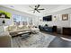 Cozy living room featuring a plush sectional sofa, modern ceiling fan, and ample natural light at 591 Mclernon Trace, Johns Island, SC 29455