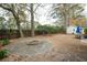 Backyard features a stone fire pit surrounded by greenery and a table with an umbrella at 642 Bridlewood Ln, Mount Pleasant, SC 29466