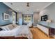 Modern bedroom showcasing a blue accent wall, natural light, ceiling fan, and stylish furniture at 668 Ferry St, Mount Pleasant, SC 29464