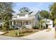 Angle view of a two story home with white siding, metal roof, and gravel driveway at 668 Ferry St, Mount Pleasant, SC 29464