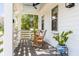 Charming covered porch with rocking chairs, stylish ceiling fan and potted plants at 668 Ferry St, Mount Pleasant, SC 29464