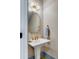 Chic powder room featuring a pedestal sink, gold mirror, and designer wallpaper at 668 Ferry St, Mount Pleasant, SC 29464