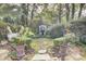 Lush backyard with intricate stone pathway, potted ferns, and manicured hedges at 710 S Main St, Summerville, SC 29483