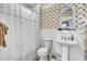 Charming bathroom with white subway tile, patterned wallpaper, and classic fixtures at 710 S Main St, Summerville, SC 29483