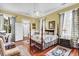 Beautiful bedroom features a four-poster bed, wood floors, and natural light at 710 S Main St, Summerville, SC 29483