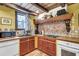 Charming kitchen with rustic cabinets, wood countertops, and tiled backsplash below a beamed ceiling at 710 S Main St, Summerville, SC 29483
