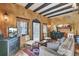 Comfortable living room showcasing neutral walls, wooden beams, and stylish furnishings leading to the kitchen at 710 S Main St, Summerville, SC 29483