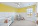 Sunny Bedroom featuring a crib, rocker, ceiling fan, board and batten, and natural light at 743 Redbud Ln, Summerville, SC 29486