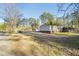 Wide view of home, gravel drive, and surrounding yard and treeline at 754 Miriam Ln, Ridgeville, SC 29472
