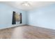 Airy bedroom with pastel blue walls, modern wood-look floors, and a view through the window framed by dark curtains at 754 Miriam Ln, Ridgeville, SC 29472