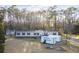 Exterior view of a home with a lush green lawn, storage shed, and wooded area in the background at 754 Miriam Ln, Ridgeville, SC 29472