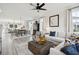 Bright, open-concept living room with hardwood floors, a ceiling fan, and views into the kitchen and dining area at 758 Blueway Ave, Summerville, SC 29486