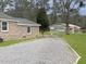 Long gravel driveway leading to a brick home and other structures, providing plenty of parking space and a rustic charm at 760 Royle Rd, Ladson, SC 29456