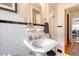 Bathroom boasts a pedestal sink with decorative accents, a mirror, and fresh flowers at 95 Plymouth Ave, Charleston, SC 29412