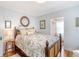 Bright bedroom features a floral bedspread, hardwood floors, and a round mirror above the bed at 95 Plymouth Ave, Charleston, SC 29412