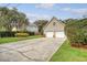 The image shows a long driveway leading to a two-car garage, surrounded by lush greenery and mature trees at 95 Plymouth Ave, Charleston, SC 29412