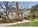 Inviting two-story home with mature landscaping, brick chimney, and a well-manicured front lawn for curb appeal at 95 Plymouth Ave, Charleston, SC 29412