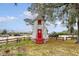 Quaint community windmill with red door surrounded by mature trees, parking, and grassy area at 95 Plymouth Ave, Charleston, SC 29412