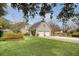 View of a spacious two-car garage with a well-manicured lawn and mature trees, framed by foliage at 95 Plymouth Ave, Charleston, SC 29412