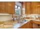Well-lit kitchen with a stainless steel sink, updated countertops, and wooden cabinets at 95 Plymouth Ave, Charleston, SC 29412