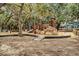 Community playground with multiple wood and rock climbing features surrounded by tall trees at 95 Plymouth Ave, Charleston, SC 29412