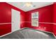 Empty red bedroom featuring carpeted floors, white trim, and a window with blinds at 101 Danzid Dr, Summerville, SC 29483