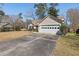 Tan house with a two-car garage and a spacious driveway on a sunny day at 101 Danzid Dr, Summerville, SC 29483
