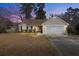 Charming single-story home with a two-car garage, manicured lawn, and inviting curb appeal at dusk at 101 Danzid Dr, Summerville, SC 29483