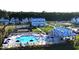 Aerial view of a sparkling community pool with lounge chairs and umbrellas surrounded by colorful homes at 1022 House Finch Ave # Cc3-22-10P, Ravenel, SC 29470