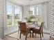 Bright dining area features stylish light fixture and a table set for four near large windows at 1022 House Finch Ave # Cc3-22-10P, Ravenel, SC 29470