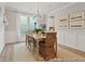 Bright dining room with a long wooden table, wicker chairs, and stylish chandelier at 1022 House Finch Ave # Cc3-22-10P, Ravenel, SC 29470