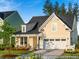 Charming two-story home with a covered front porch, attached two-car garage, and manicured lawn at 1022 House Finch Ave # Cc3-22-10P, Ravenel, SC 29470