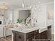 Open-concept kitchen with a large island, granite countertops, stainless steel sink, and dark cabinets at 1022 House Finch Ave # Cc3-22-10P, Ravenel, SC 29470