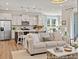 Open-concept living room and kitchen offers comfortable seating and modern stainless steel appliances at 1022 House Finch Ave # Cc3-22-10P, Ravenel, SC 29470
