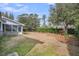 Large leaf covered backyard featuring brick house, a screened porch, and mature trees at 103 Night Hawk Ln, Summerville, SC 29485