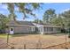 Leaf covered backyard featuring brick house, a screened porch, and mature trees at 103 Night Hawk Ln, Summerville, SC 29485