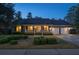 Charming brick home at twilight featuring an inviting front porch and attached two-car garage at 103 Night Hawk Ln, Summerville, SC 29485