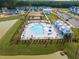 Aerial view of a resort-style community pool, playground, and lounge area surrounded by beautiful homes at 1045 Northern Flicker Dr # Cc3-19-5P, Ravenel, SC 29470