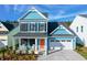 Charming two-story home features a blue exterior, black shutters, and a welcoming front porch with rocking chairs at 1045 Northern Flicker Dr # Cc3-19-5P, Ravenel, SC 29470