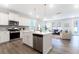 Open concept kitchen with island, stainless steel appliances, and view into the inviting living room at 1045 Northern Flicker Dr # Cc3-19-5P, Ravenel, SC 29470