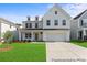 Charming two-story white farmhouse with a well-manicured lawn and a two-car garage at 1047 House Finch Ave # Cc3-19-2P, Ravenel, SC 29470