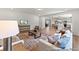 Spacious living room with a view of the kitchen and dining area, featuring neutral furniture and hardwood floors at 1047 House Finch Ave # Cc3-19-2P, Ravenel, SC 29470