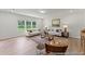 Bright living room with neutral furniture, wood floors, a patterned rug, and large windows at 1047 House Finch Ave # Cc3-19-2P, Ravenel, SC 29470