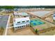 An aerial view showcasing a community clubhouse, pool and pickleball courts in a new development at 1050 Marsh Harrier Dr # Cc3-15-3P, Ravenel, SC 29470