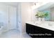Bathroom with double vanity, black cabinets, tiled floors, and white door at 1050 Marsh Harrier Dr # Cc3-15-3P, Ravenel, SC 29470