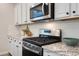Modern kitchen featuring white cabinetry, stainless steel appliances, granite countertops, and a stylish backsplash at 1050 Marsh Harrier Dr # Cc3-15-3P, Ravenel, SC 29470